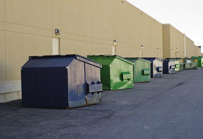 a pile of demolition waste sits beside a dumpster in a parking lot in Baldwin City